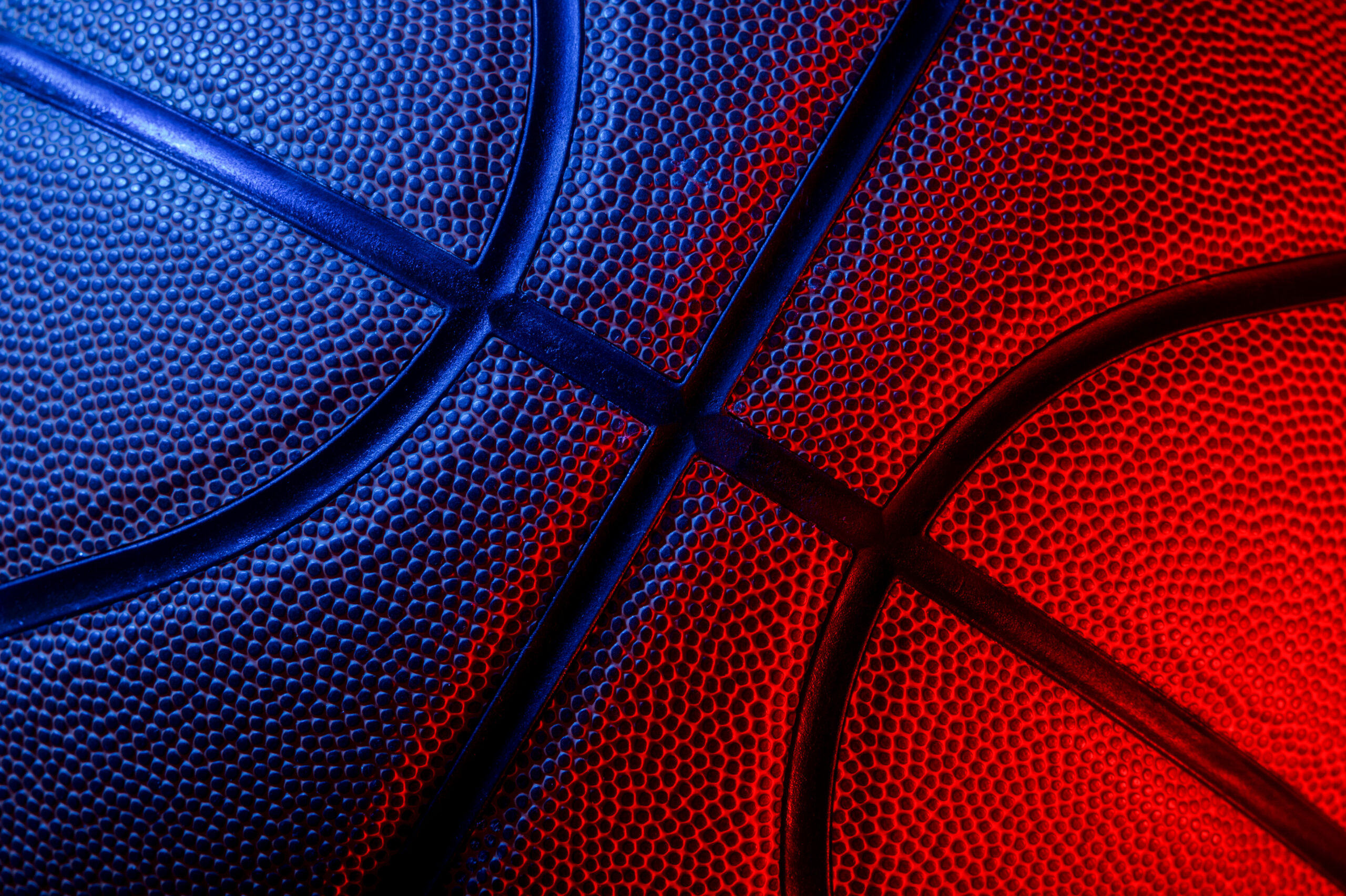 Bright red and blue close-up basketball texture reflects SCBL youth basketball development, competition, and opportunity across the Lehigh Valley since 2010.