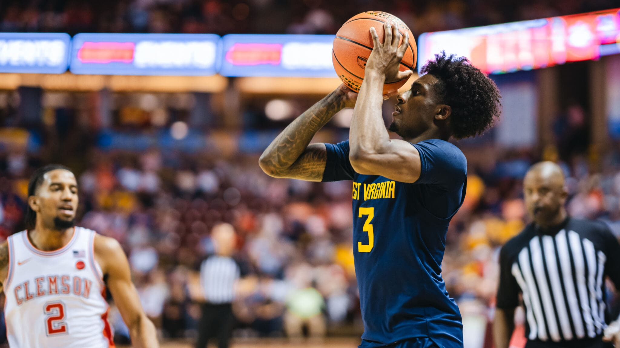 During SCBL youth basketball development, a West Virginia player shoots a free throw against Clemson in a competitive game before a referee.