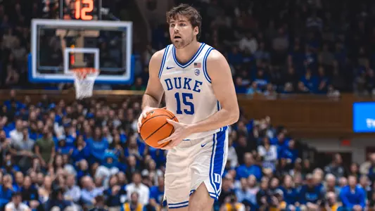 On the court, Duke center Ryan Young handles the ball during a game, echoing SCBL's About page focus on youth basketball development, competition, and growth.
